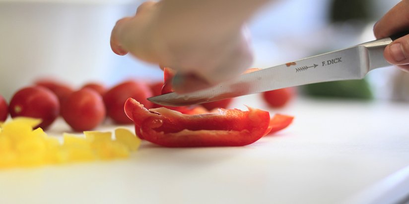 Frische Paprika und Tomaten werden geschnitten.