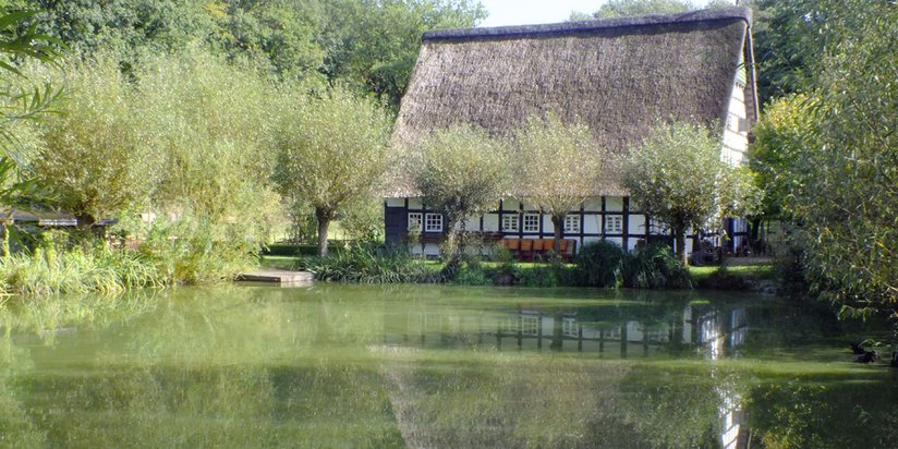 Kleiner See vor einem schmucken Fachwerkhaus 