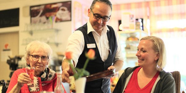 Ein Mitarbeiter serviert Getränke in der Cafeteria.