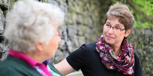 Bewohnerin und Mitarbeiterin in ein Gespräch vertieft.